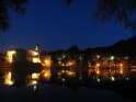 Die Lichter von Beaulieu spiegeln sich bei Nacht im Wasser der Dordogne