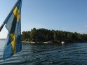 Schwedenflagge mit Schäre im Hintergrund