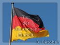 Grusskarte zum Tag der Deutschen Einheit mit einem Foto der Flagge der Einheit vor dem Reichstag