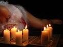 Frau im Weihnachtskostm mit brennenden Kerzen