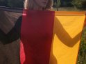 Aktfoto einer Frau, die Ihren Körper hinter einer Deutschlandflagge versteckt. Durch die Flagge hindurch sind die Umrisse des Körpers zu erkennen.