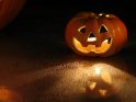 Halloweenkürbis mit leuchtenden Augen spiegelt sich am im Boden