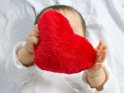 Babyhände mit einem roten Herz