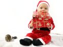 Baby im Weihnachtskostüm spielt mit einem Geschenkkarton