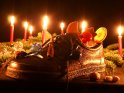 Gefllter Nikolausschuh mit Kerzen im Hintergrund