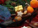 Zu einem Nikolausstiefel umgewandelter Stöckelschuh, gefüllt mit Nüssen, Mandarinen und Gebäck