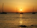 Blick auf das Mittelmeer bei Sonnenuntergang. Im Bild sind vier Segelschiffe zu sehen.