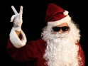 Cooler Weihnachtsmann mit Sonnenbrille hat seine linke Hand zum Victory-Zeichen geformt.