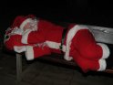Weihnachtsmann schläft auf einer Parkbank