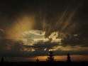 Spektakuläres Wolkenfoto kurz vor Sonnenuntergang: Einzelne Sonnenstrahlen brechen sich ihren Weg durch eine Wolkenlücke. Die einzelnen Sonnenstrahlen sind vor den dunklen Wolken besonders gut zu erkenne.