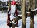 Der Nikolaus sitzt auf einer verschneiten Wippe.