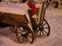 Schneebedeckter hlzerner Wagen mit einer darauf liegenden Weihnachtsmtze