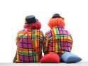 Zwei Clowns sitzen mit dem Rücken der Kamera zugewandt
