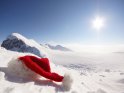 Weihnachtsmtze liegt bei strahlend blauem Himmel in einer Alpenlandschaft