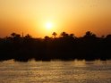 Sonnenuntergang über dem Nil mit Palmen, Minaret und einem Vogelschwarm