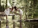 Zwei Freundinnen küssen sich über einem kleinen Fluß