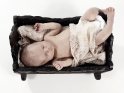 Säugling in einer antiken hölzernen Babywippe