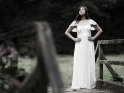 Junge Frau im Brautkleid auf einer Holzbrcke