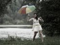 Junge Frau mit Reifen und buntem Regenschirm