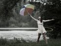 Tänzerin mit Hula Hoop Reifen und Regenschirm