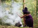 Hexe im Wald mit Rauch oder Nebel