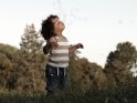 Niedliches Foto von einem kleinen Jungen, der verzückt hinter Seifenblasen hinterher schaut.