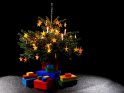 Weihnachtsbaum, geschmckt mit Kerzen und Filzsternen, mit davor liegenden Geschenkpaketen