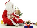 Weihnachtsmann mit einem Kleinkind auf dem Schoß, dass zu ihm hochschaut.