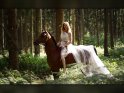 Reiterin im weien Kleid auf einem Pony im Wald