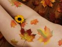 Herbstliches Bodypainting mit Ahornblättern und einer kleinen Sonnenblume