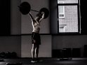 Mann mit freiem Oberkörper beim Gewichtheben