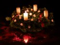 An einem Adventskranz mit weißen Kerzen und weißen Sternen brennt zum 1. Advent die 1. Kerze.