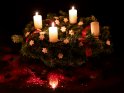 An einem Adventskranz mit weißen Kerzen und weißen Sternen brennen zum 3. Advent die ersten drei Kerzen.