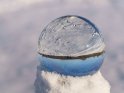 Glaskugel im Schnee mit einem in den Schnee gemalten Herz