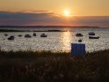 Sonnenuntergang an der Kieler Förde mit Strandkorb und Booten im Vordergrund