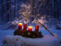 Adventskranz im Schnee mit zwei brennenden Kerzen zum 2. Advent.